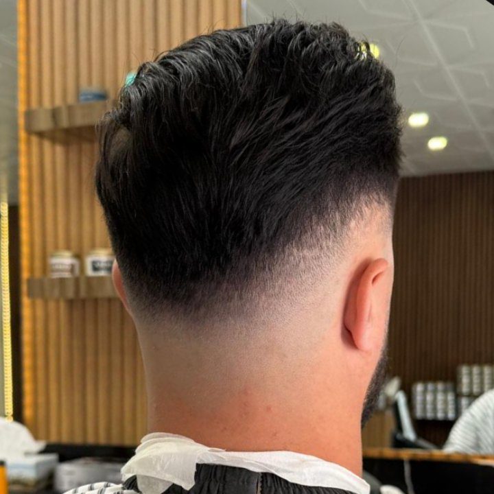 Textured top and taper fade from above at Nasim Barbershop