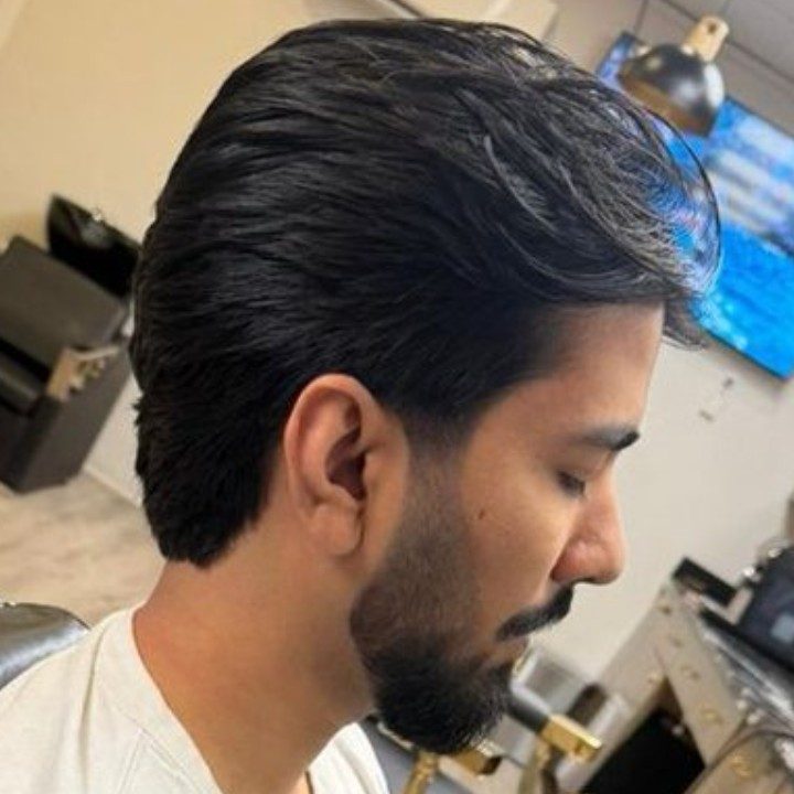 Side profile of pompadour, beard trim, and clean fade at Nasim Barbershop