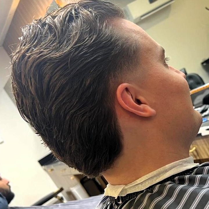 Textured pompadour with tapered neckline fade at Nasim Barbershop
